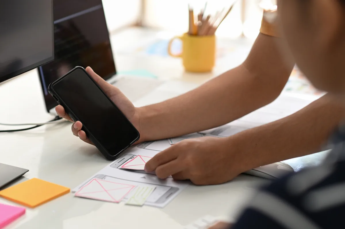 A designer prototyping mobile app screens at a desk