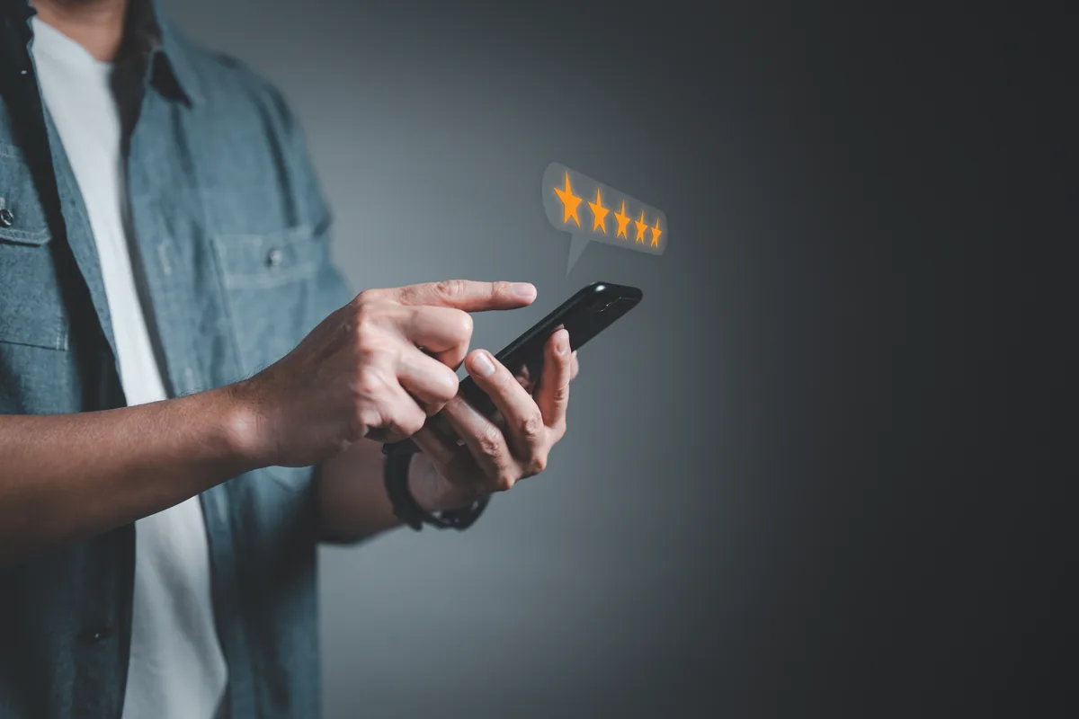 A customer leaving a five star rating on a smartphone
